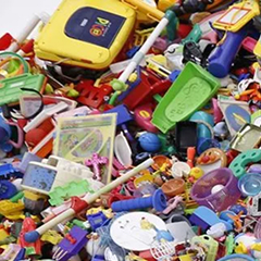 A child sits in the middle of a room full of toys